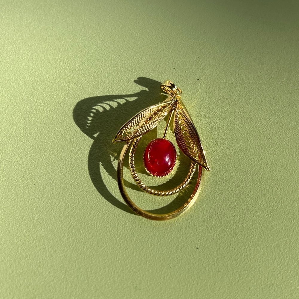 Gold filigree pendant with red jewel